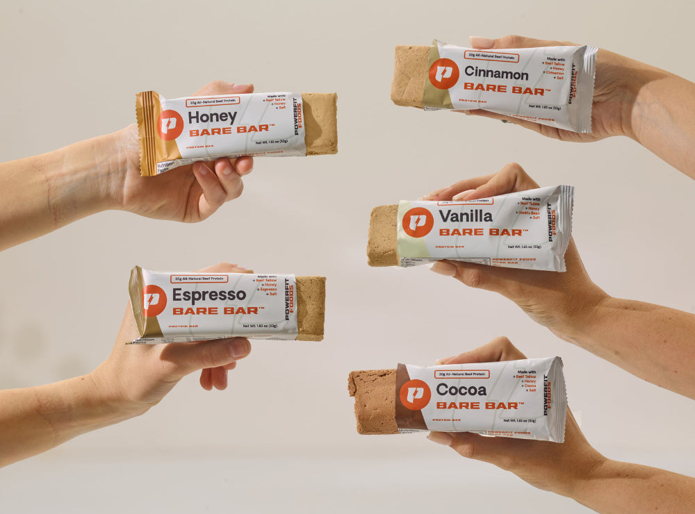 Hands holding different flavors of Bare Bars against a neutral background